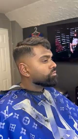 Finished skin fade with a textured top and a sharp beard
