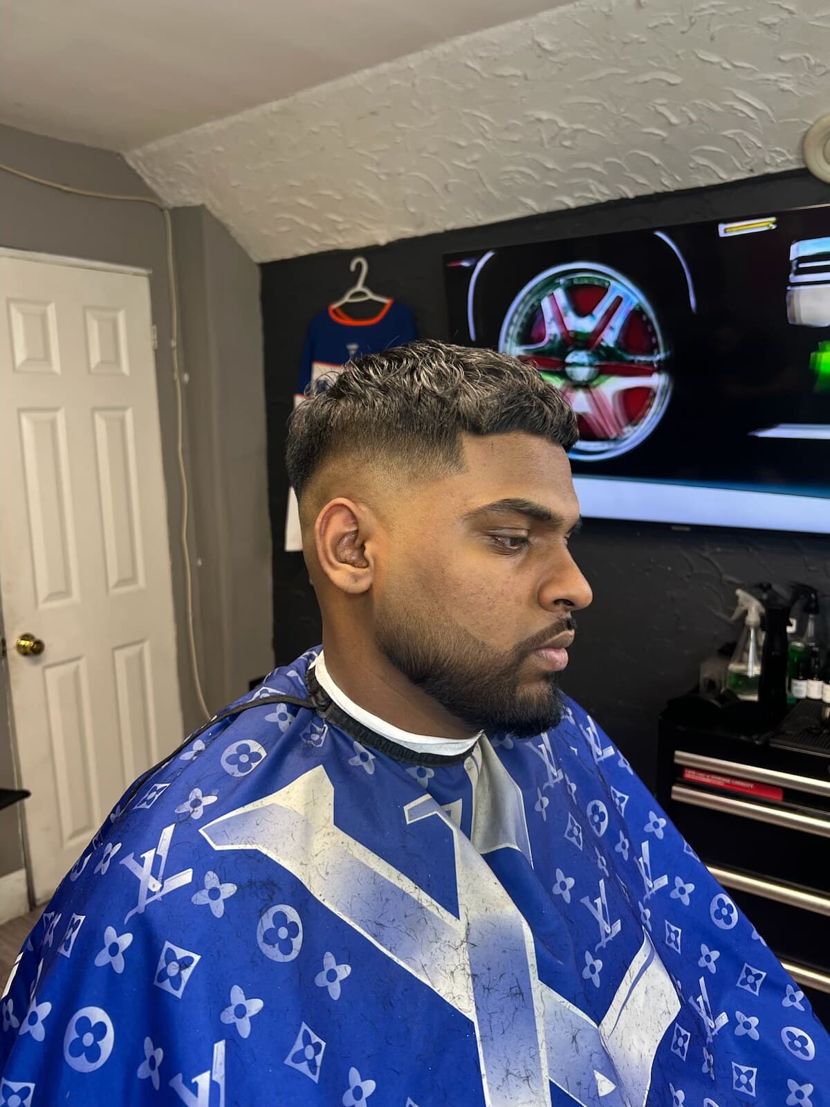 Finished mid fade with a textured top and a full beard